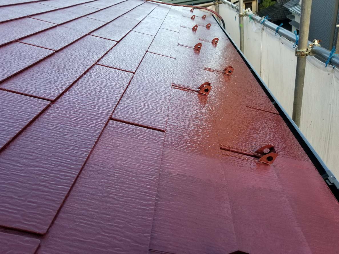 赤い塗料を塗り重ねて艶が生まれた古いスレート屋根