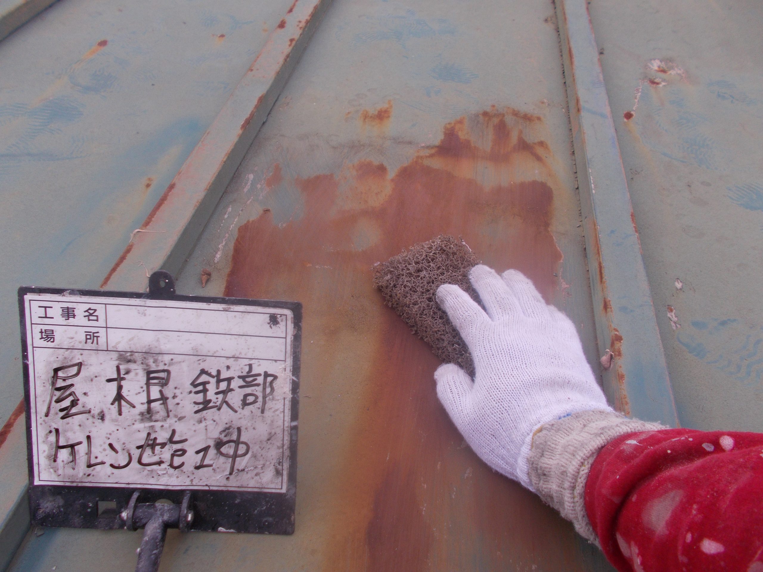 金属屋根をケレンで下地処理中