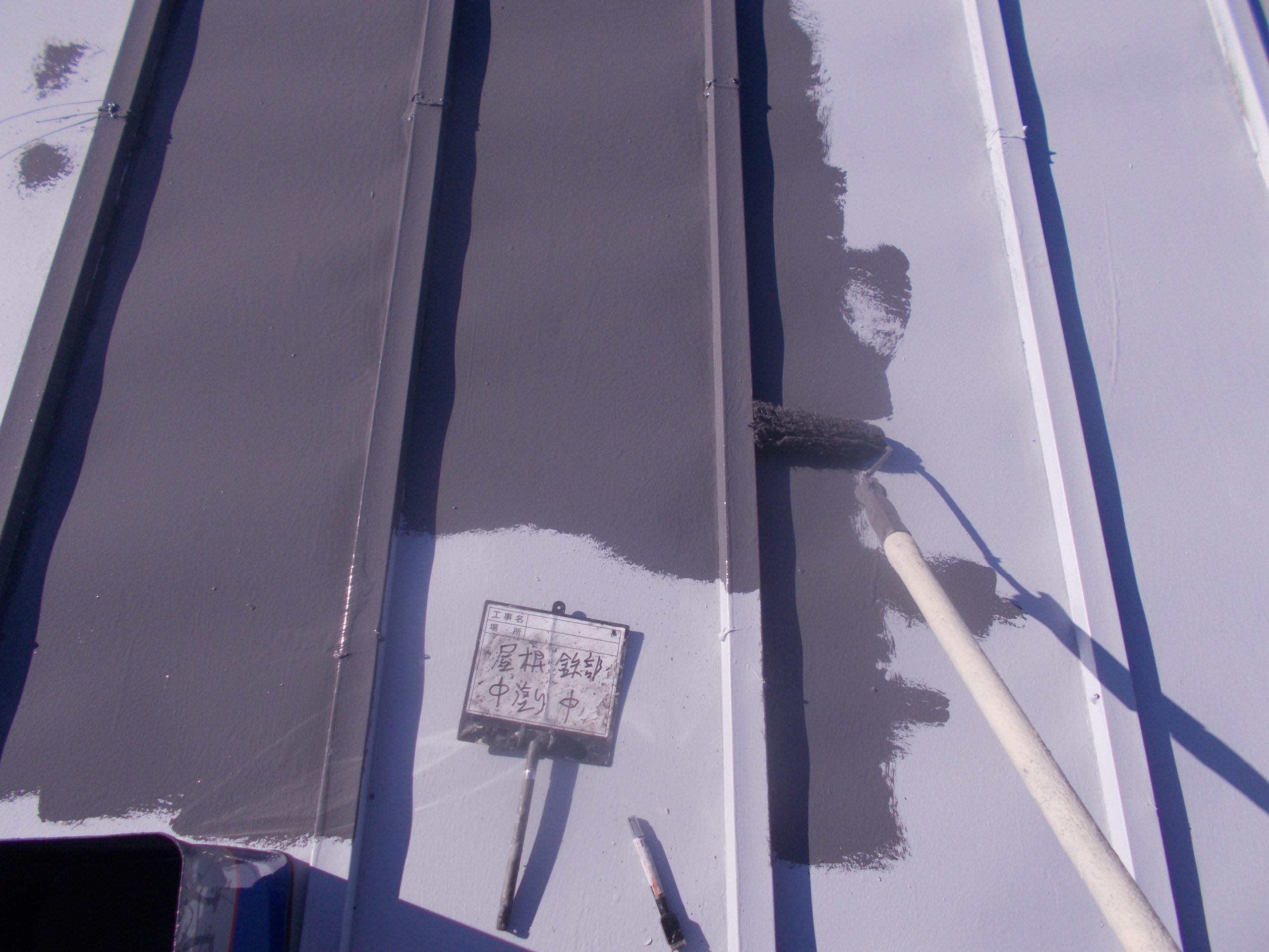 金属屋根に中塗り塗装中