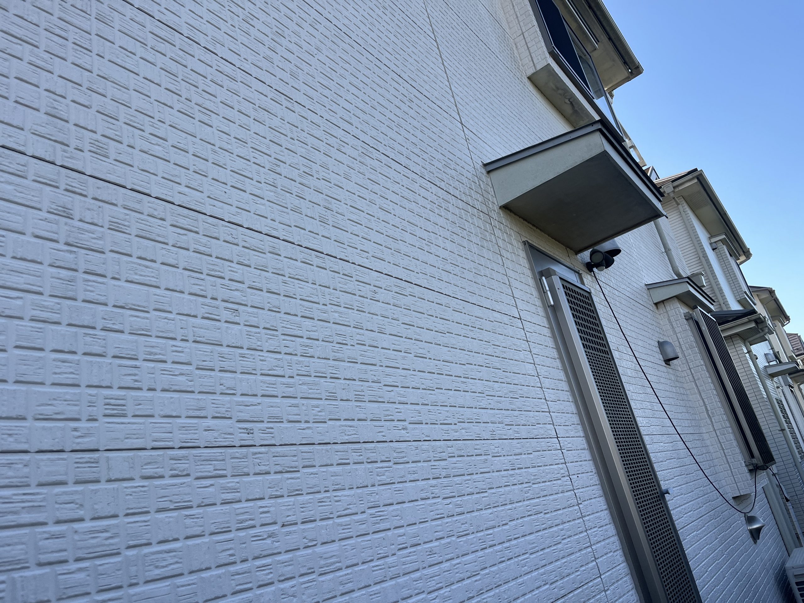 外壁が反り始めている白い外壁