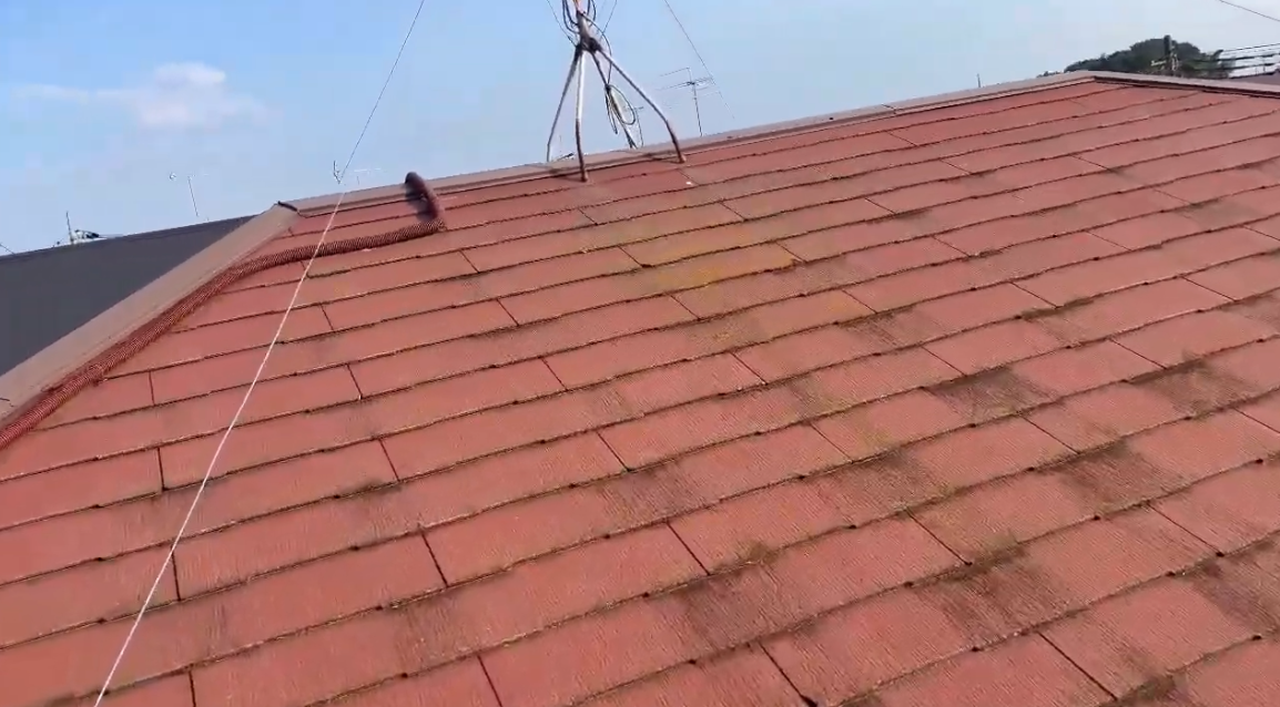 茶色い苔が目立つ赤いスレート屋根