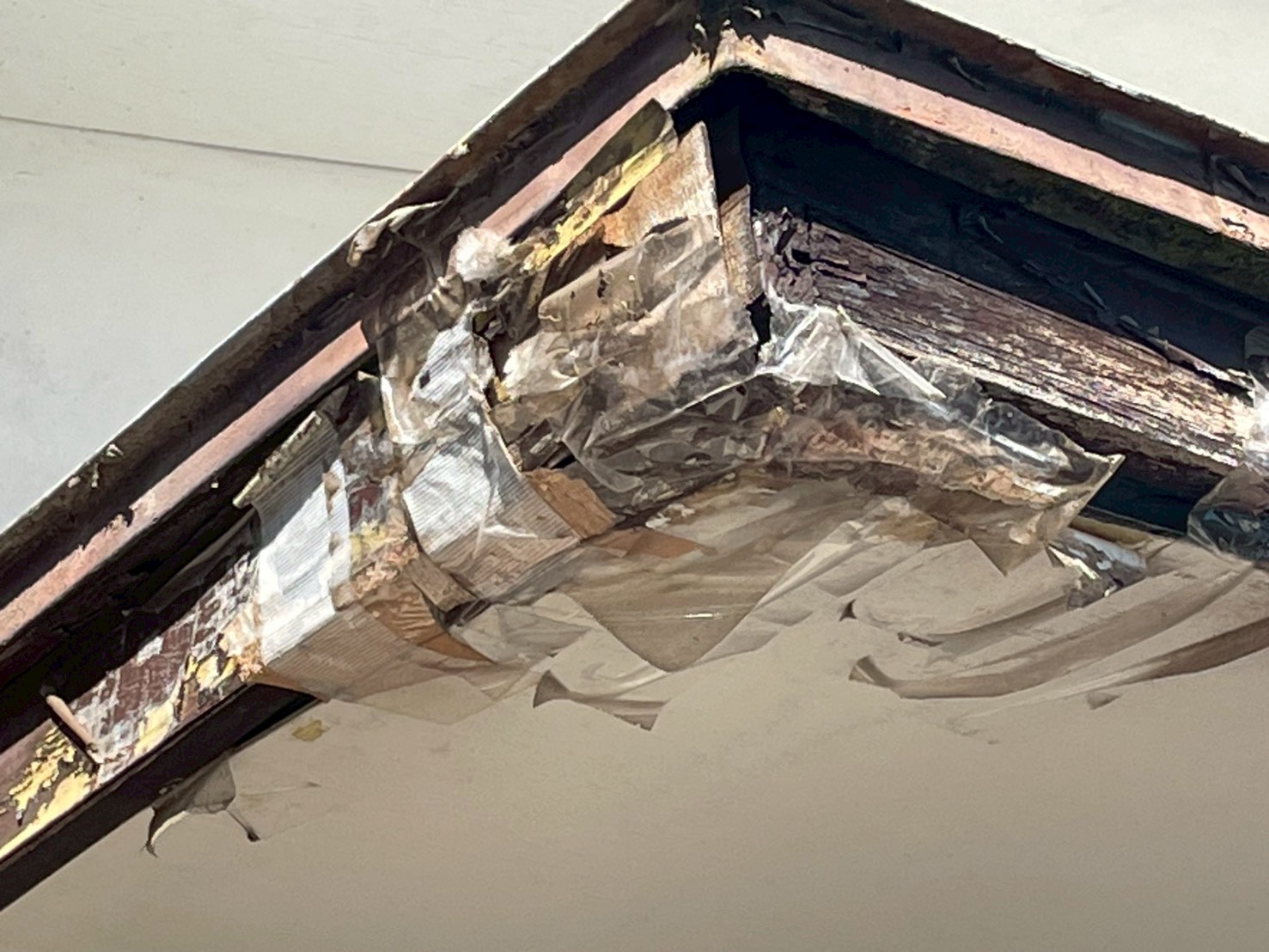 腐食して剥がれた破風板をテープで補強している