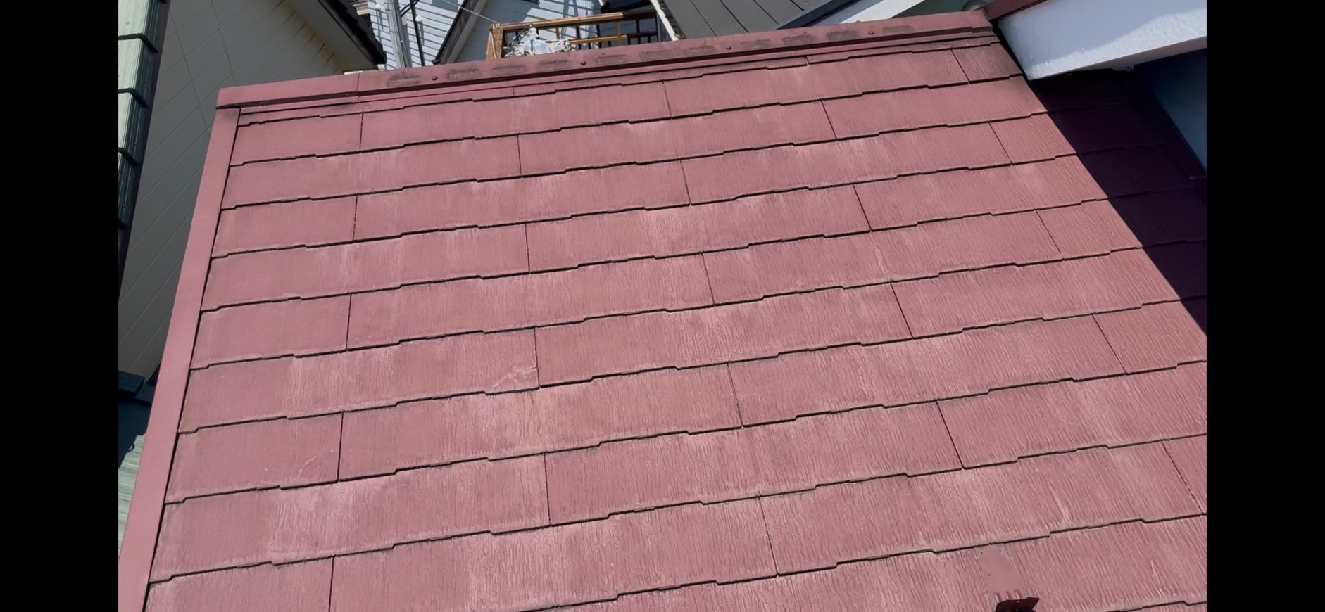 全体的に色褪せが進行している赤いスレート屋根