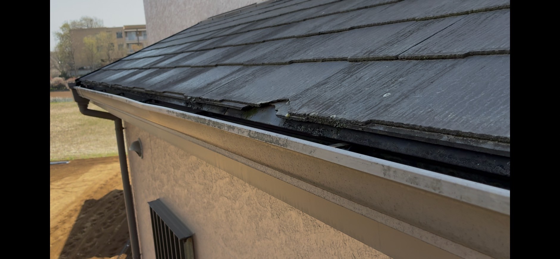 落下物によって破損したスレート屋根