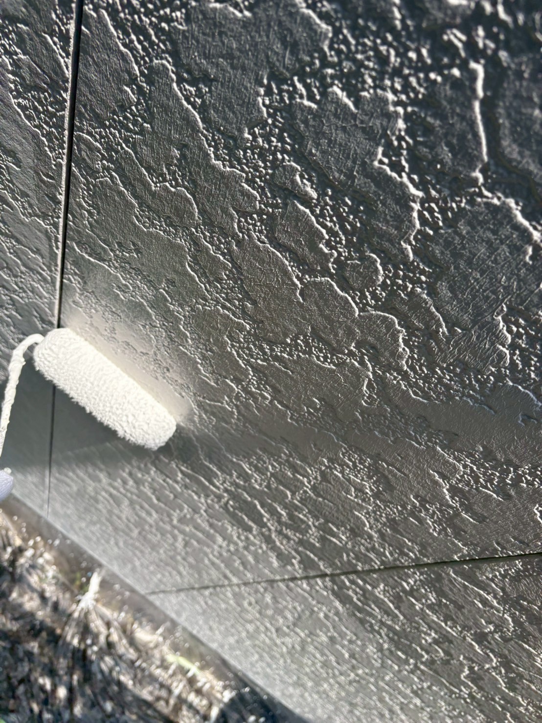 白い外壁に下塗り施工中