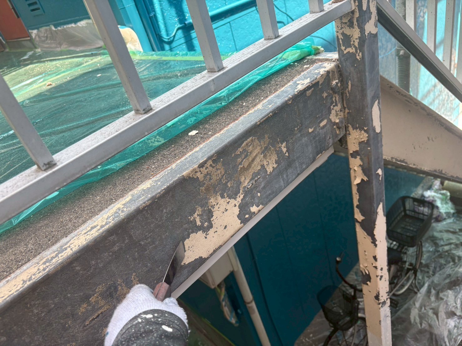 ケレンで古い塗料を剥がしている鉄骨階段