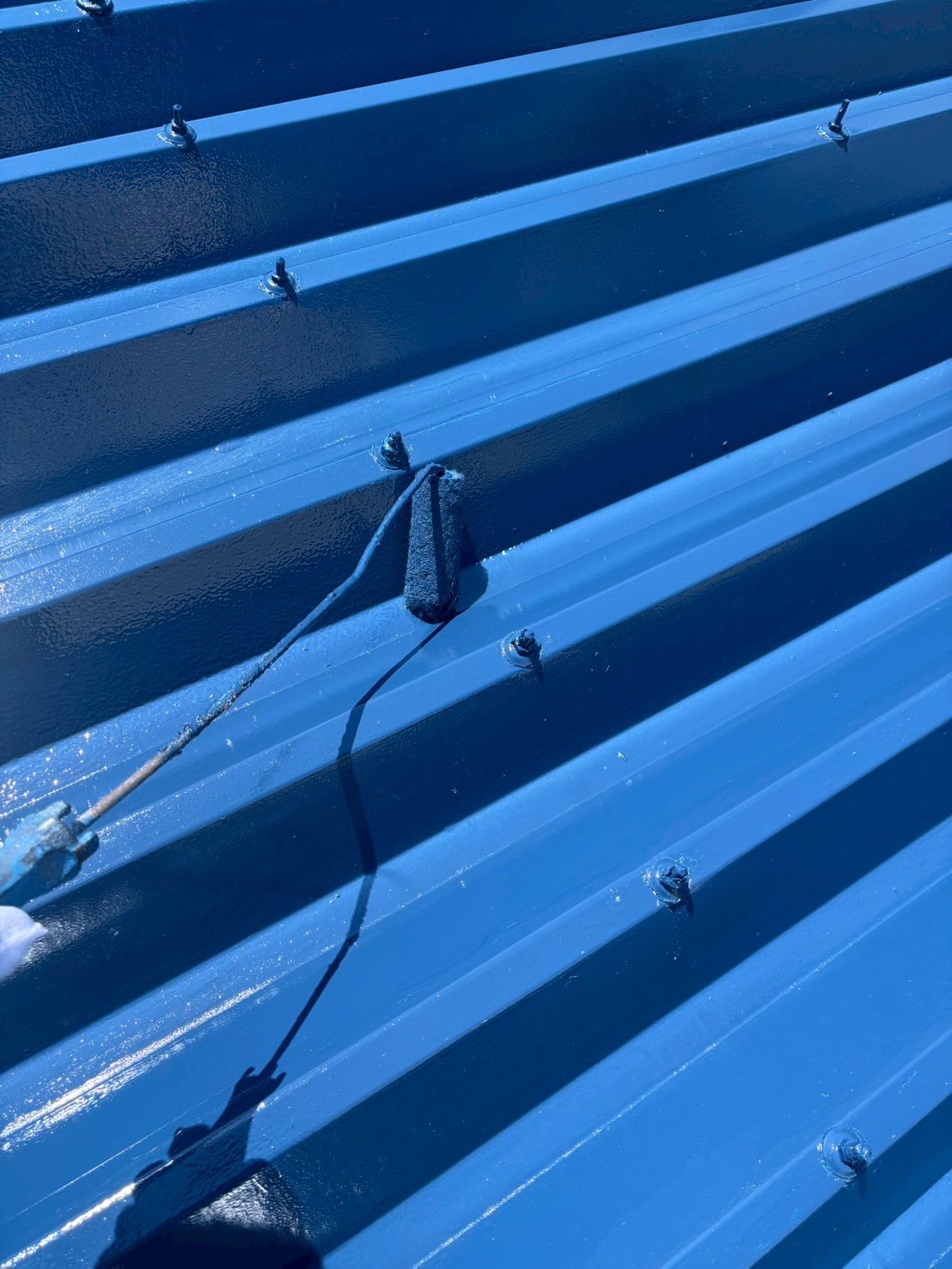 上塗りを折半屋根に施工中