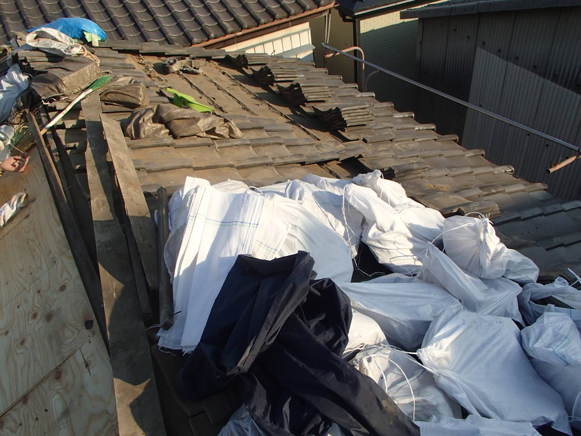 瓦撤去作業が進み少しずつ下地が見えてきた屋根