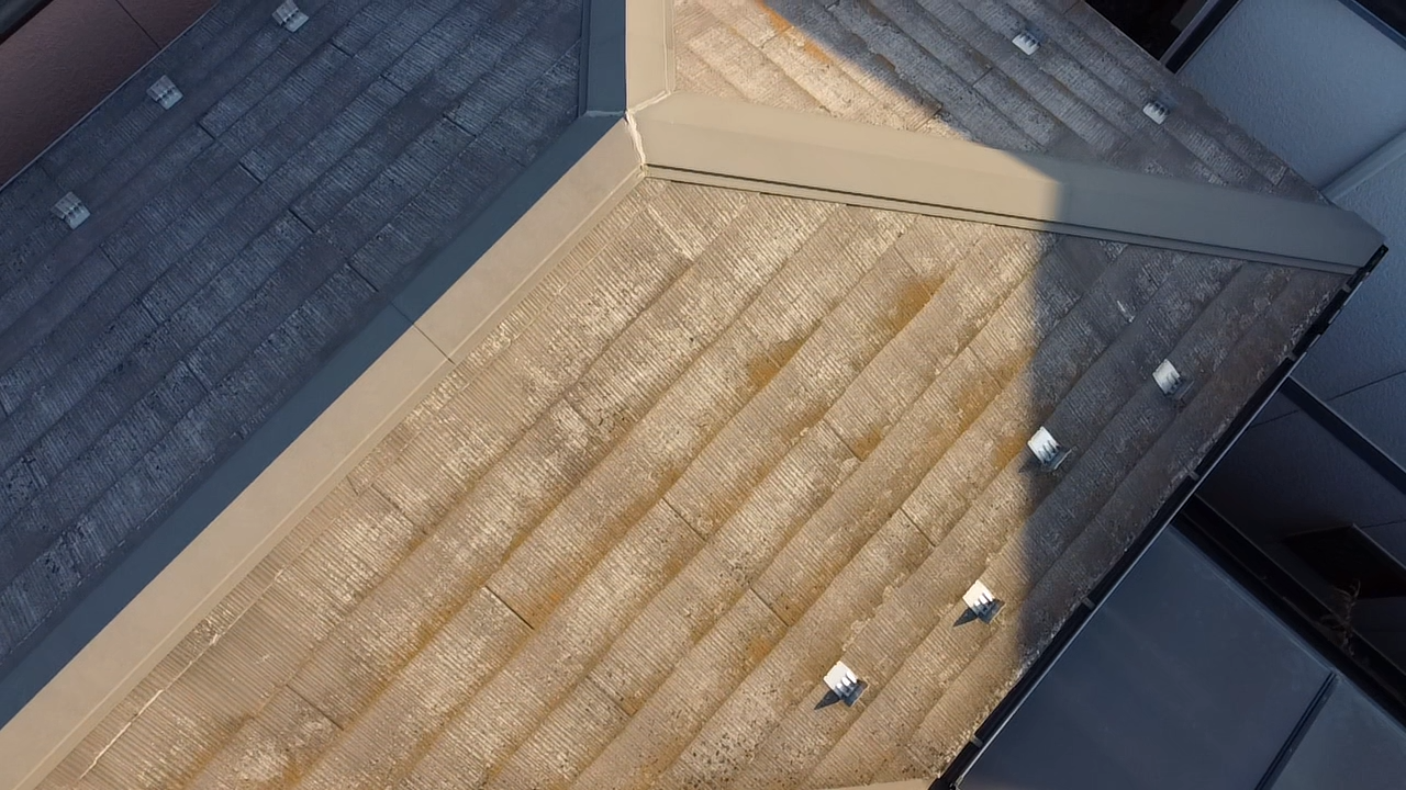 苔が生えた寄棟のスレート屋根